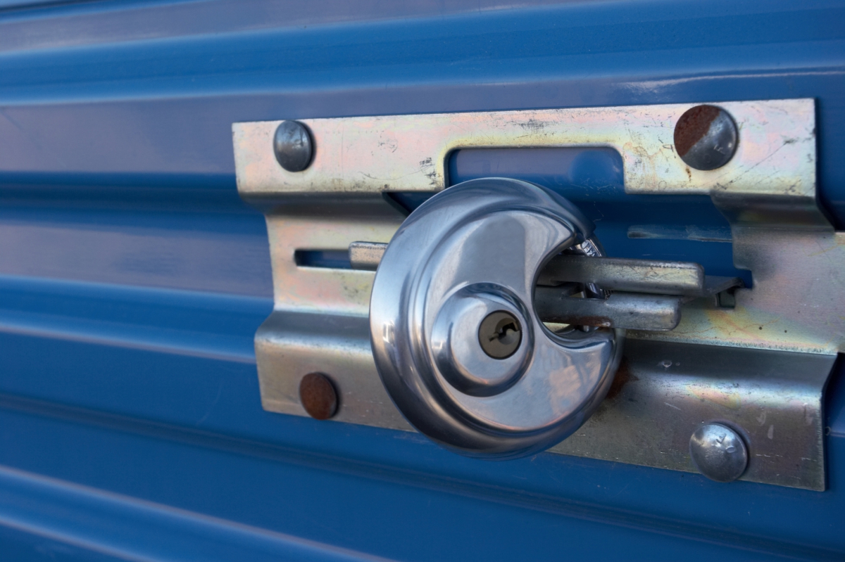 Metal padlock on blue storage unit door