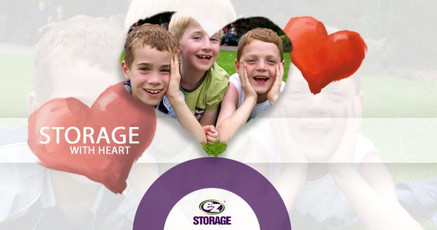 Three boys smiling with red hearts with EZ Storage logo and text "Storage With Heart"