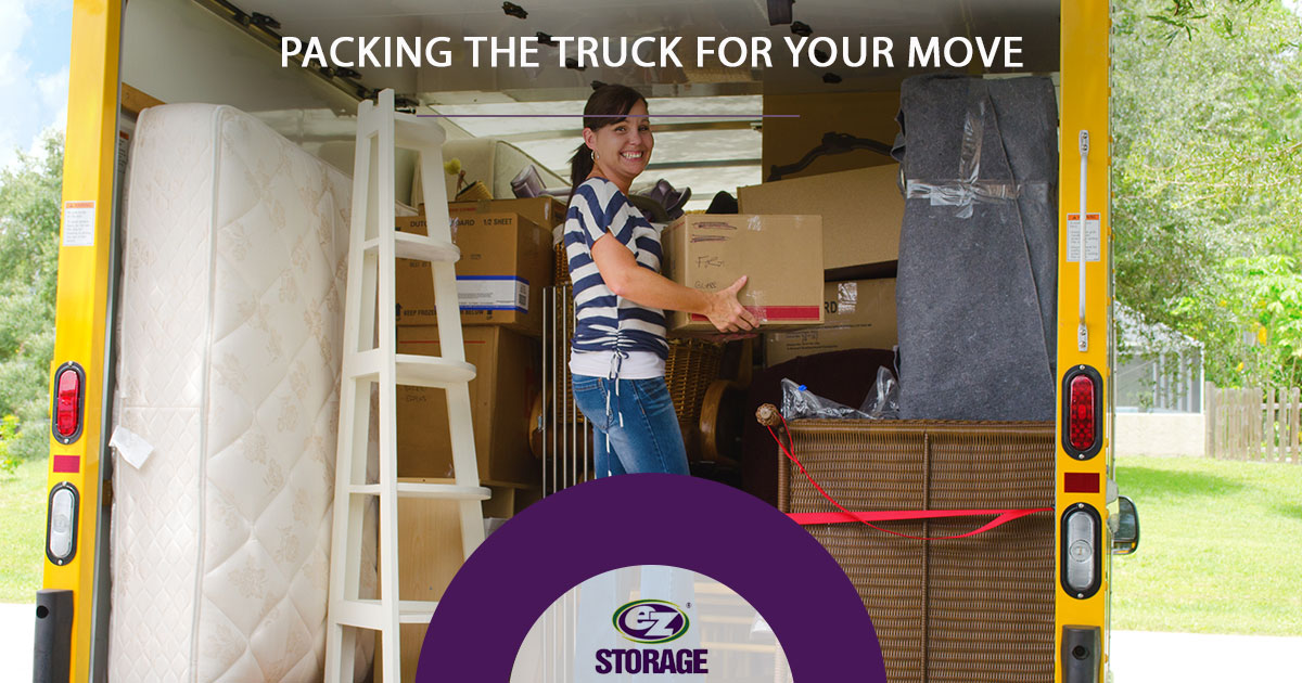 Women holding box inside moving truck and text "Packing the truck for your move"