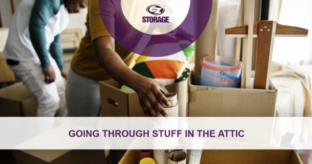 Two people looking through open boxes and text "Going through stuff in the attic"