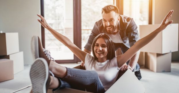 Man pushing a women with her arms up inside a box