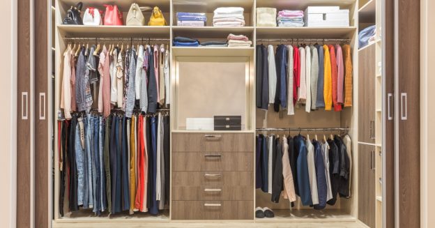 Walk in closet with clothes hanging from racks