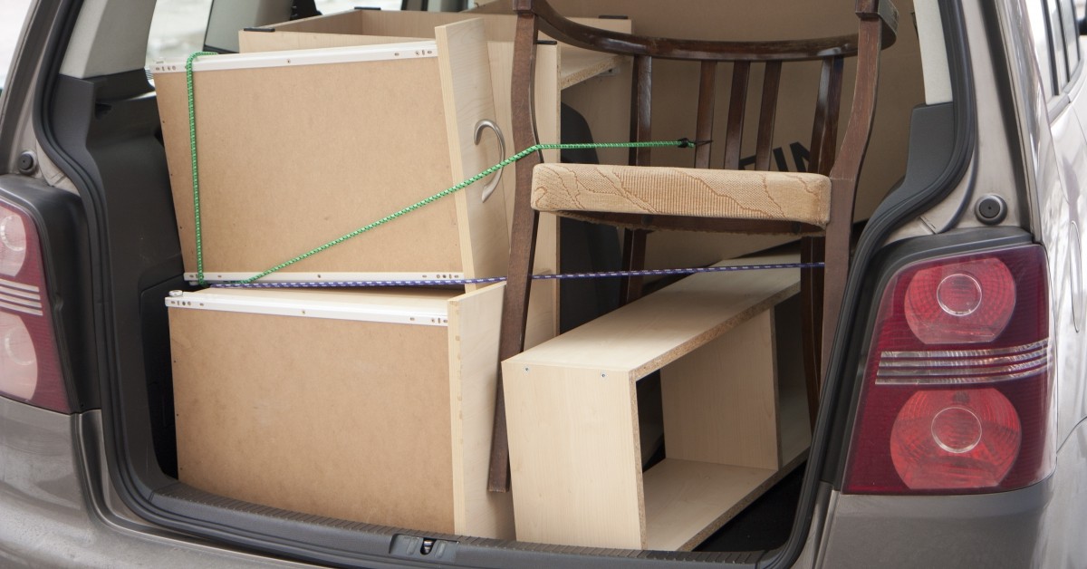 Furniture packed in the back of an SUV or van, tied down with bunjie cables for a move