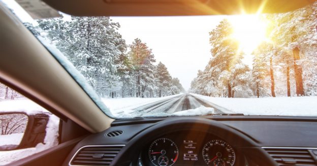 View from driver seat of car facing out onto road with snow