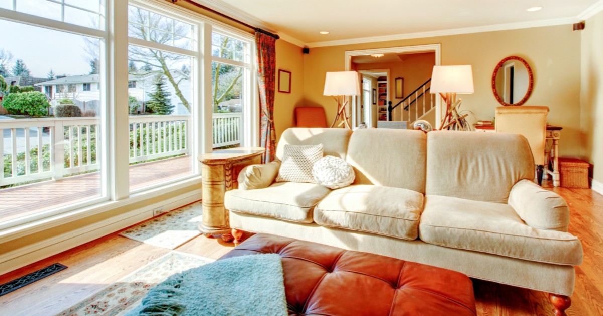 Interior of a residential living room with window view of porch and neighborhood