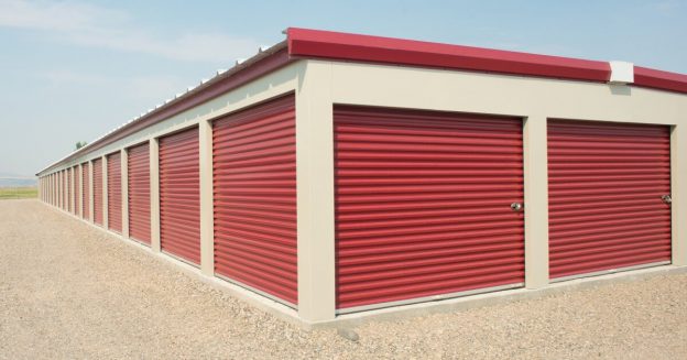 Exterior view of storage unit facility with red shuttered doors.