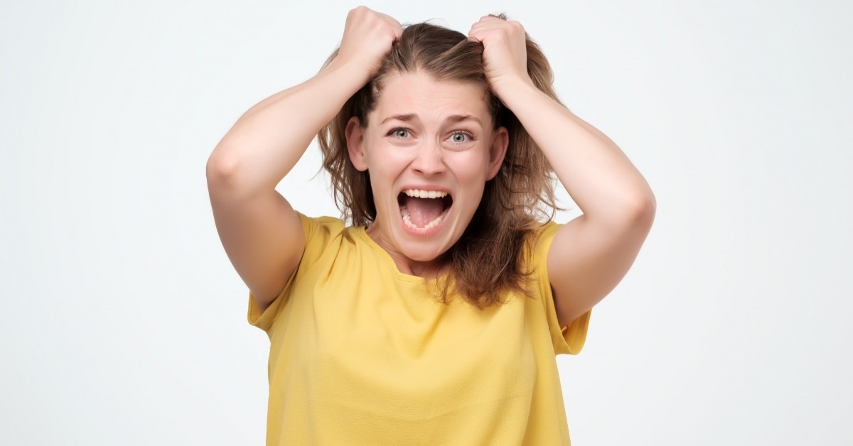 Close up of woman pulling her hair up and yelling