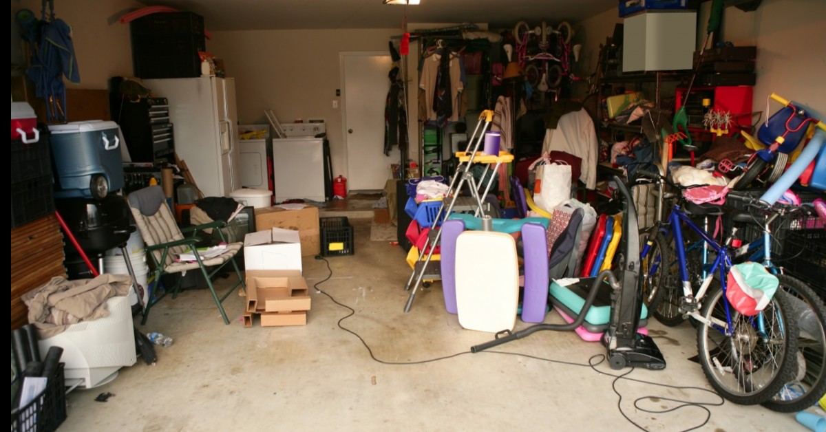 A view of a messy garage with toys, bicycles, clothes, and other stored items