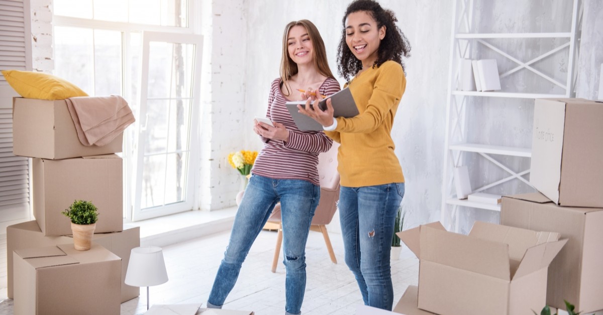 Two young women packing for college