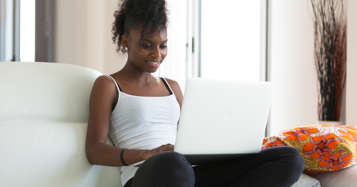 Young woman sitting on a couch using a laptop