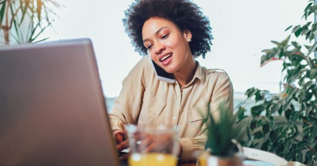 Young woman sitting outdoors using a computer