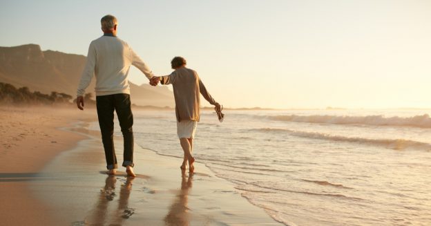 A couple walking on the beach holding hands