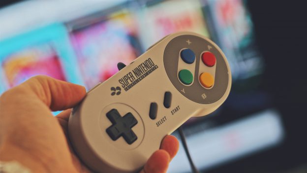 Hand holding Super Nintendo controller