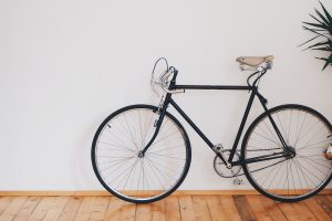 black bicycle standing up on white wall